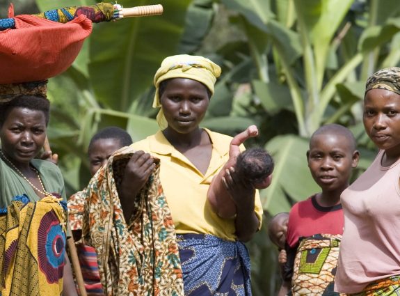 A group of women in vibrant traditional clothing in a rural setting